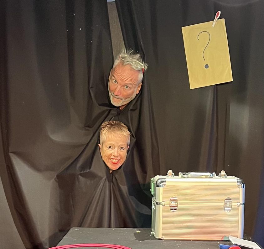 le magicien et son assistante devant un rideau de scene avant le debut de spectacle